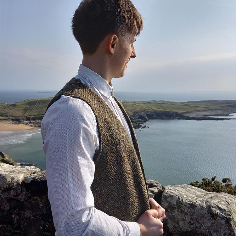 Young man wearing a tweed waistcoat standing by the shore in Kilcak, County Donegal.